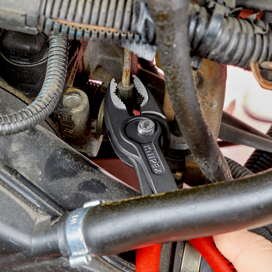 KNIPEX TwinGrip Frontgreifzange 82 01 200 im Einsatz an Motorblock mit Schläuchen und Metallteilen
