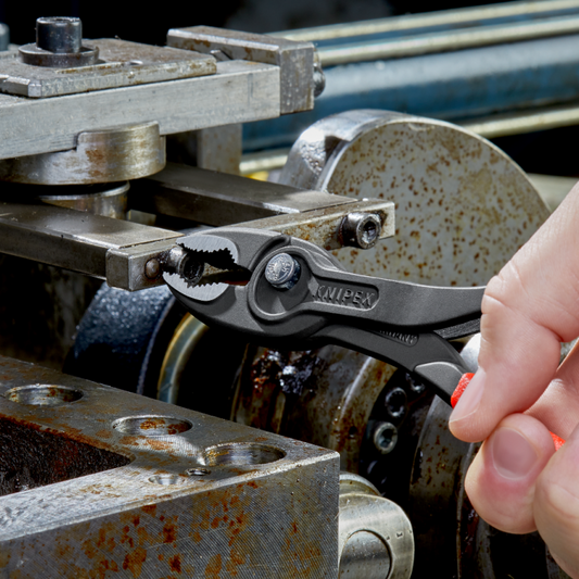 KNIPEX TwinGrip Frontgreifzange mit Druckknopfverstellung beim Greifen einer Schraube in Werkstattpraxis