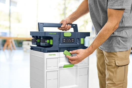Festool SYS-MC 6/4 Schnellladegerät mit Systainer, Mann lädt vier Akkus parallel, grüne Bedienelemente sichtbar