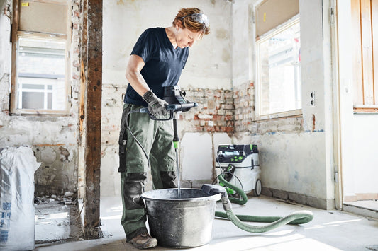 Festool MX 1000 RE Rührwerk mit MX-Absaugung beim Mischen in Eimer auf Baustelle, Absaugschlauch angeschlossen