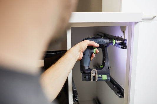 Festool CXS 18 Akku-Bohrschrauber in ergonomischer C-Form wird angewendet an weißem Möbel