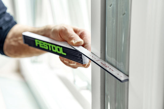 Festool Meterstab Holzgliedermaßstab wird zur Längenmessung an Türrahmen angewendet, dunkelblau mit grünem Logo