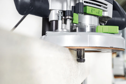 Festool OF 2200 EB-Plus Oberfräse mit grünem Bedienfeld beim Fräsen in Holzwerkstück