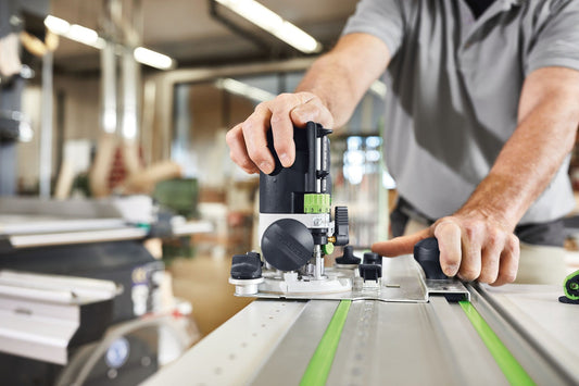 Festool OF 1010 REBQ-FS Oberfräse mit Führungsschiene bei Fräsarbeit auf Werkstück in Werkstatt