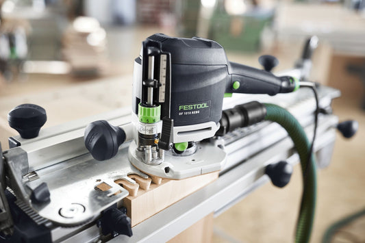 Festool Oberfräse OF 1010 REBQ mit LED-Lichtring auf Frästisch montiert, Fräser und Zubehör sichtbar