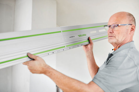 Festool Führungsschiene mit Verbindungsstück FSV/2 wird von Handwerker an Wand ausgerichtet und angebracht