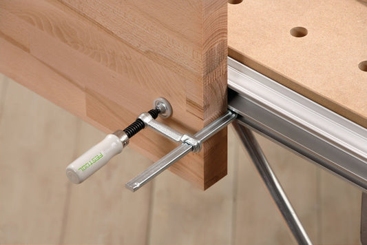 Festool Schraubzwinge FSZ 120 beim Spannen einer Holzplatte mit Führungsschiene und Spannzubehör