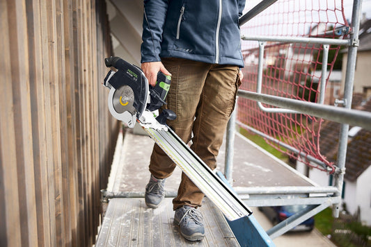 Festool HKC 55 Akku-Handkreissäge mit Kappschiene FSK 420 beim Längskappen an Holzwerkstück auf Baustelle