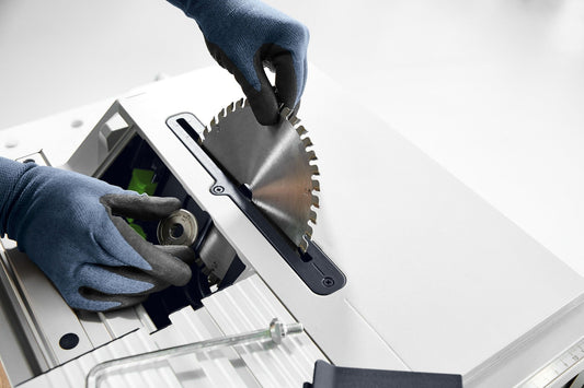 Festool Kreissägeblatt-Set KSB-SORT/3 W/L/A wird mit Schutzhandschuhen in Sägenmaschine eingesetzt.