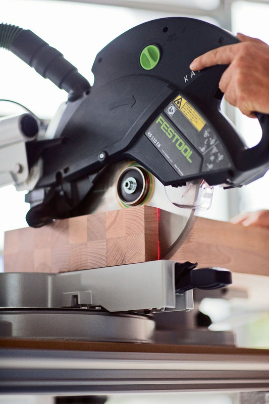 Festool KAPEX KS 120 REB Kapp-Zugsäge beim Schneiden eines Holzwerkstücks mit Doppellinien-Laser