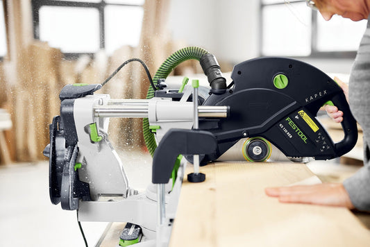 Festool KAPEX KS 120 REB Kapp-Zugsäge sägt Holz mit Doppellinien-Laser und grüner Absauganlage.