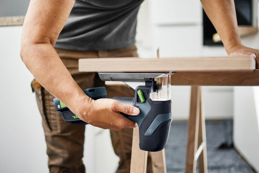 Festool PSC-E 18 Akku-Pendelstichsäge beim Sägen von Holz mit 90°-Tisch in der Hand gehalten