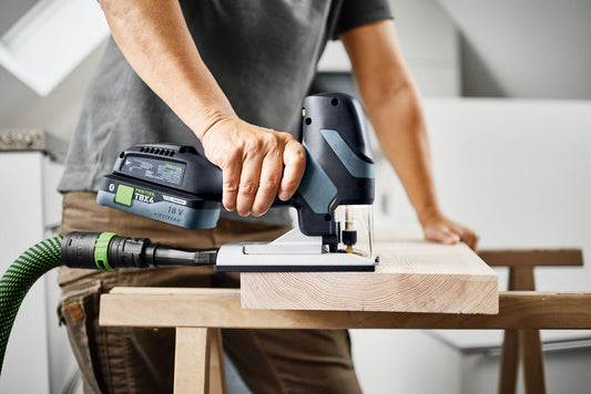 Festool PSC-E 18 Akku-Pendelstichsäge mit Akku TBX4 beim Sägen von Holz auf Werkbank mit Führungsrolle