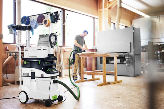 Festool CLEANTEC CTM 48 EI AC Absaugmobil mit Zubehörmobil in Werkstatt, Arbeiter schleift Holz