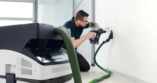 Festool CTMC MIDI Akku-Absaugmobil mit Schlauch und Elektrowerkzeug in Anwendung