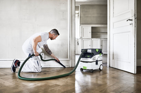Festool CLEANTEC CTM MIDI I Absaugmobil in Anwendung beim Staubabsaugen auf Holzparkett mit Saugschlauch