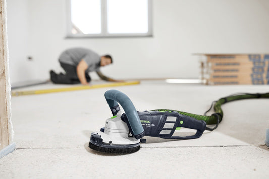 Festool RENOFIX RG 130 Sanierungsschleifer mit Bürstensegment in Anwendung beim Schleifen bis zur Wand auf Betonboden