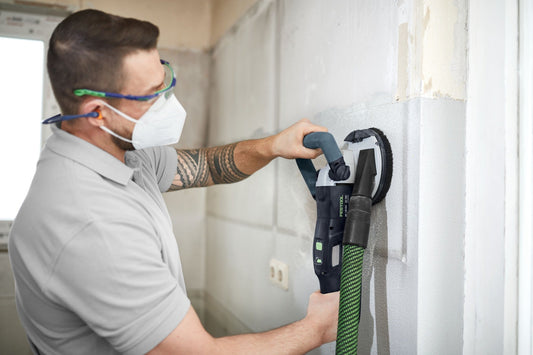 Festool Sanierungsschleifen RG 80 mit Diamantscheibe an Wand, Arbeiter mit Schutzausrüstung