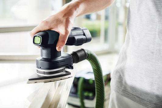 Festool Schleifer mit Deltaschleifteller und grünem Absaugschlauch bei der Anwendung