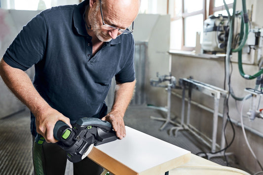 Festool Kantenschleifer ES-ETS 125 REQ-Plus beim Schleifen einer Holzkante mit winkeltreuer Auflage in Werkstatt