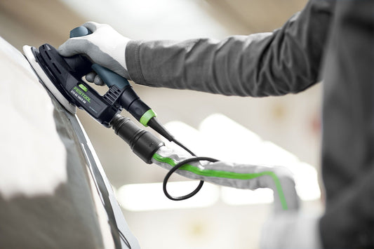 Festool ETS EC 150/5 EQ-Plus Exzenterschleifer mit grünem Stromkabel in Anwendung beim Schleifen einer weißen Oberfläche