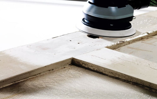 Festool ETS 150/5 EQ Exzenterschleifer beim Schleifen von Betonoberfläche mit Schleifteller im Einsatz
