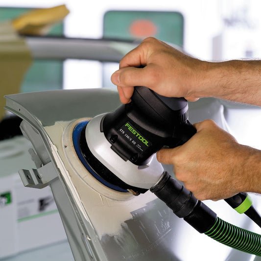 Festool ETS 150/5 EQ-Plus Exzenterschleifer in Anwendung auf Holzoberfläche mit Absaugschlauch