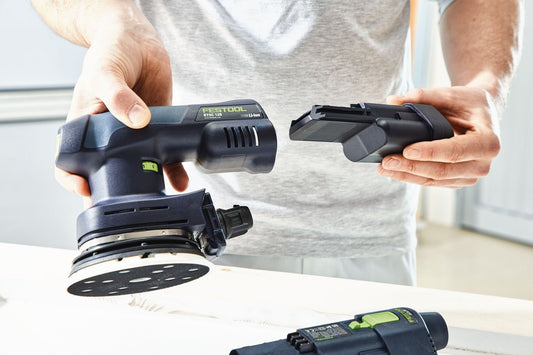 Festool ETSC 125-Basic Akku-Exzenterschleifer mit auswechselbarem StickFix Schleifteller und Akkupack in Händen.