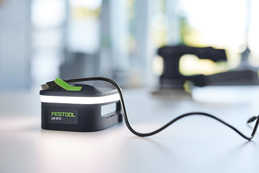 Festool Lichtmodul LM-RTS mit LED-COB-Technik, grünem Tragegriff und USB-C Anschluss auf Arbeitstisch