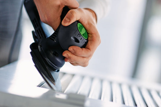 Festool Schleifschuh mit grünem Schalter in Hand, StickFix Klettbelag sichtbar