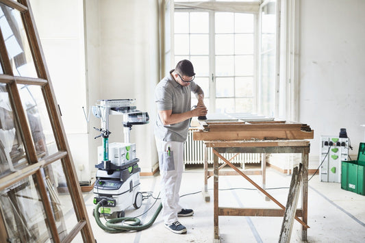 Festool Absaugmobil CLEANTEC CTM 26 EI AC im Einsatz beim Schleifen von Holzbalken in der Werkstatt