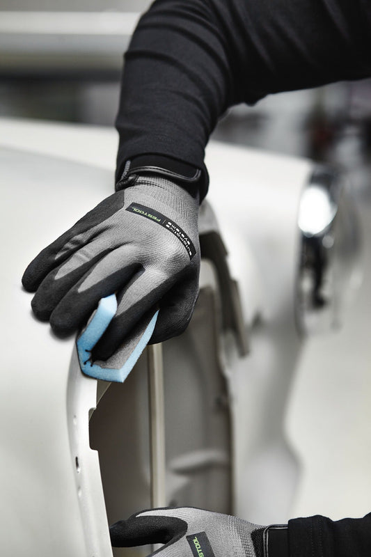 Festool Handschleifschwamm Granat in Anwendung mit Schutzhandschuhen beim Schleifen einer Oberfläche