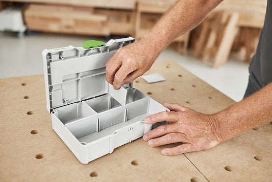 Festool Systainer³ SYS3 S 76 geöffnet mit Trennstegen, Handgriff und grüner Verschlusslasche auf Werkbank sichtbar.